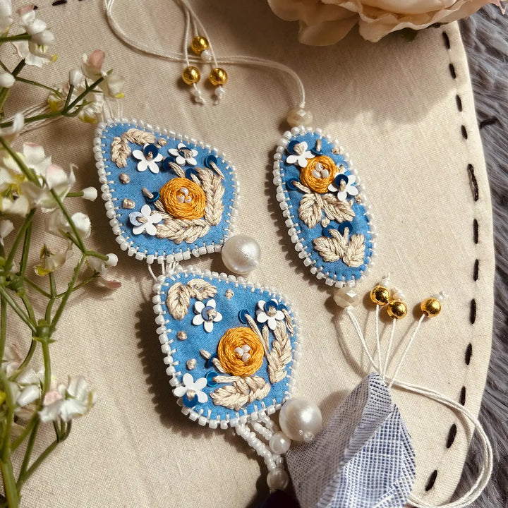 Hand Embroidered Blue Floral Bhaiya Bhabhi Rakhi With Roli Chawal Set Of 2 - Close-up of entire set