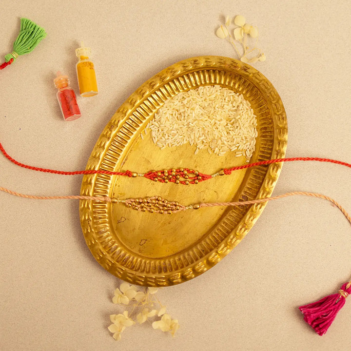 Handmade Crochet Noori Moti Rakhi With Roli Chawal Set Of 2 - Flat lay showing full strands