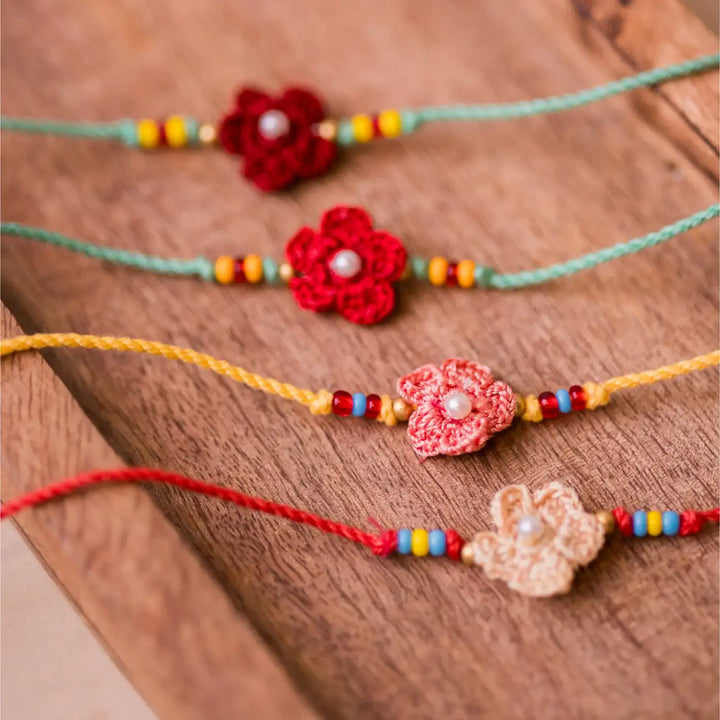 Handmade Crochet Pink Daisies Rakhi With Roli Chawal Set Of 4 - Close-up of green flower bracelets