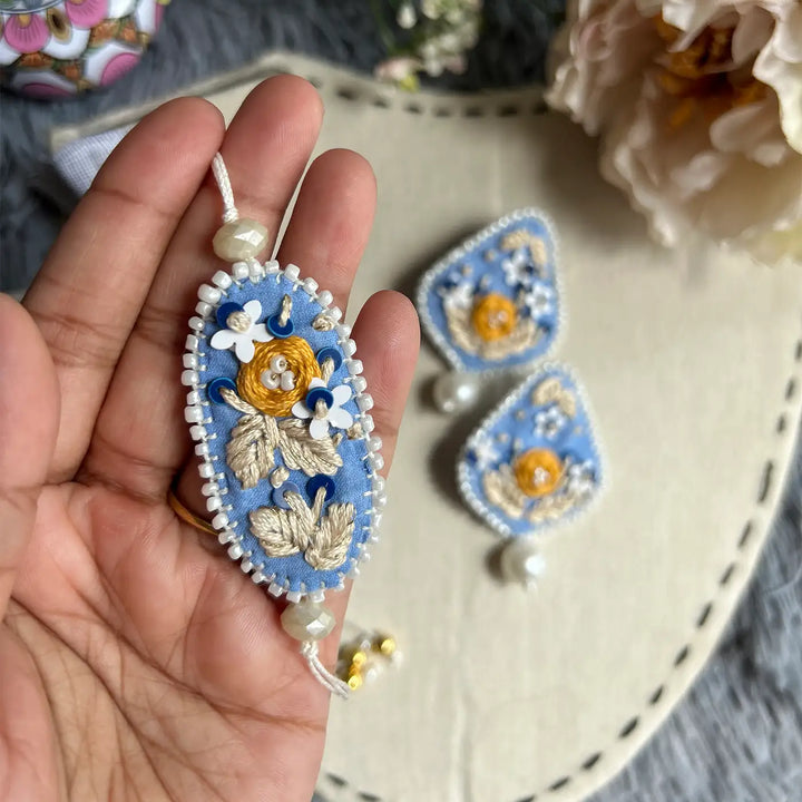 Hand Embroidered Blue Floral Bhaiya Bhabhi Rakhi With Roli Chawal Set Of 2 - Single piece held in hand
