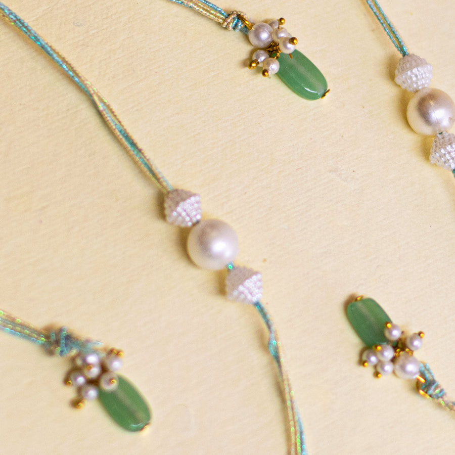 Handmade White Pearl And Ghungroo Rakhi With Roli Chawal - Close-up Multiple Rakhis