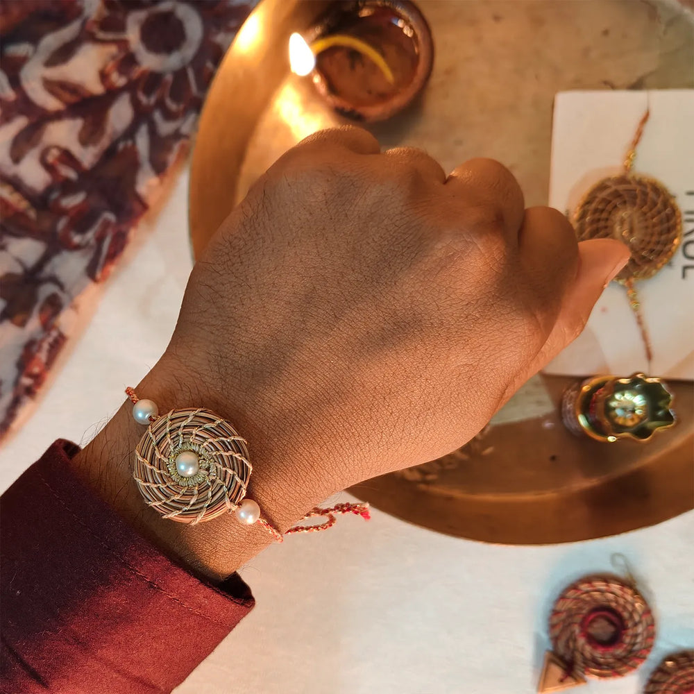 Eco Friendly Handmade Gold And Pearl Pine Needle Rakhi With Pouch And Roli Chawal - Worn on Wrist