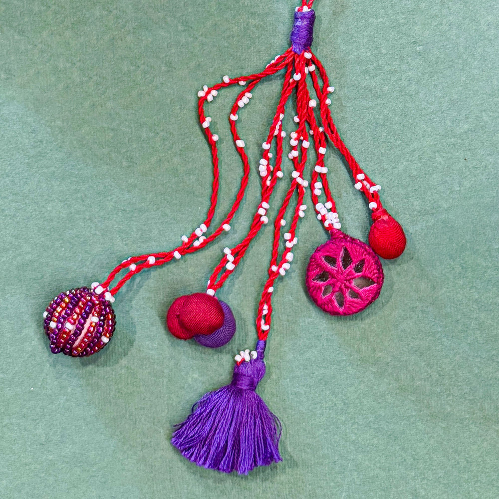 Handmade Reusable Pink Patwa Ari Mirror And Potli Rakhi For Bhabhi - Close-up of Decorative Tassel Details