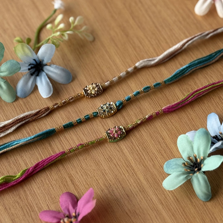 Handmade Stone Embedded Flower Rakhi With Roli Chawal - Group Laid Flat with Flowers