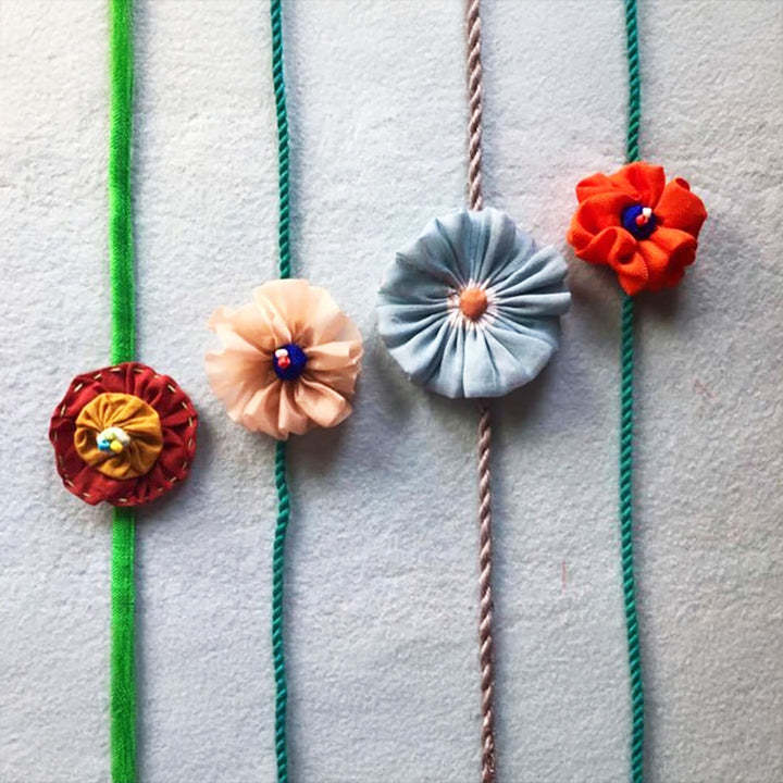 Handmade Flower Bloom Design Upcycled Fabric Rakhi With Roli Chawal For Brother - Front View of Multiple Hairbands