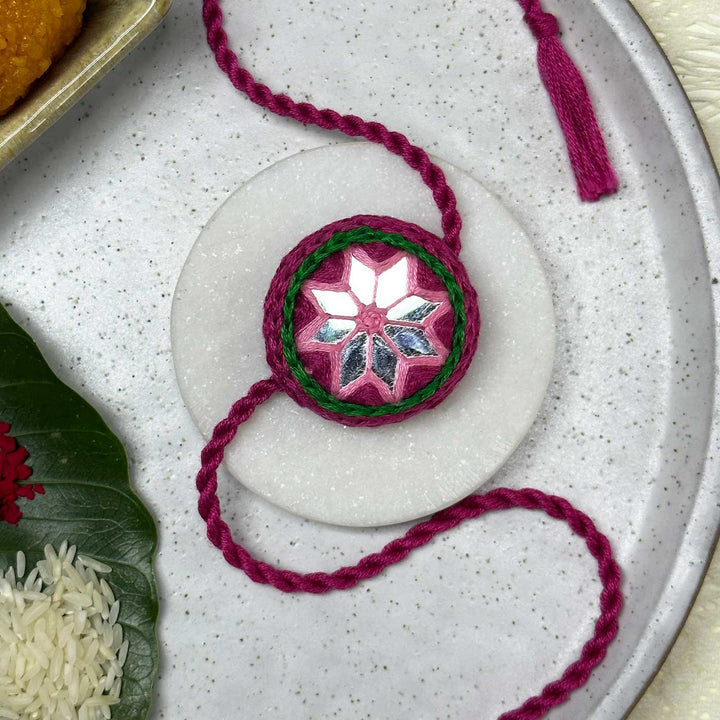 Customized Handmade Mirror Work Cotton Rakhi With Roli Chawal - Styled Front View on Plate