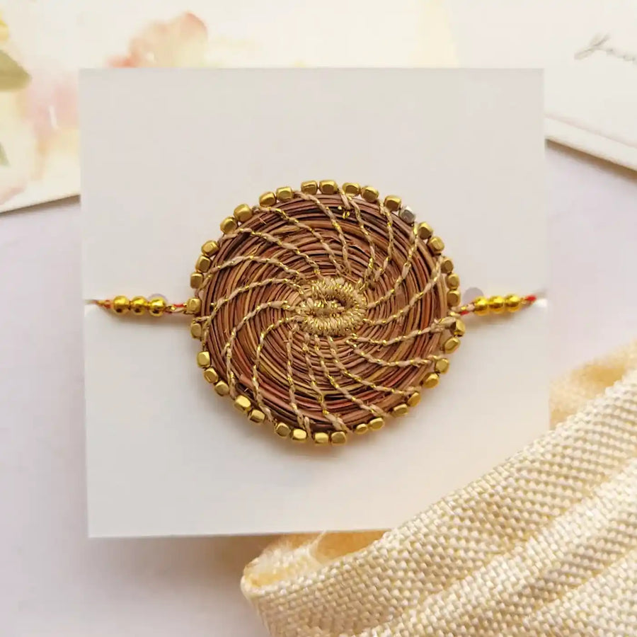 Eco Friendly Handmade Gold Beads Pine Needle Rakhi With Pouch And Roli Chawal - Close-up Front View
