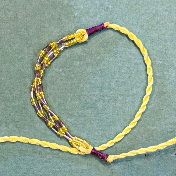 Handmade Reusable Yellow Corel And Jhumki Rakhi For Brother - Close-up of Knot and Beadwork