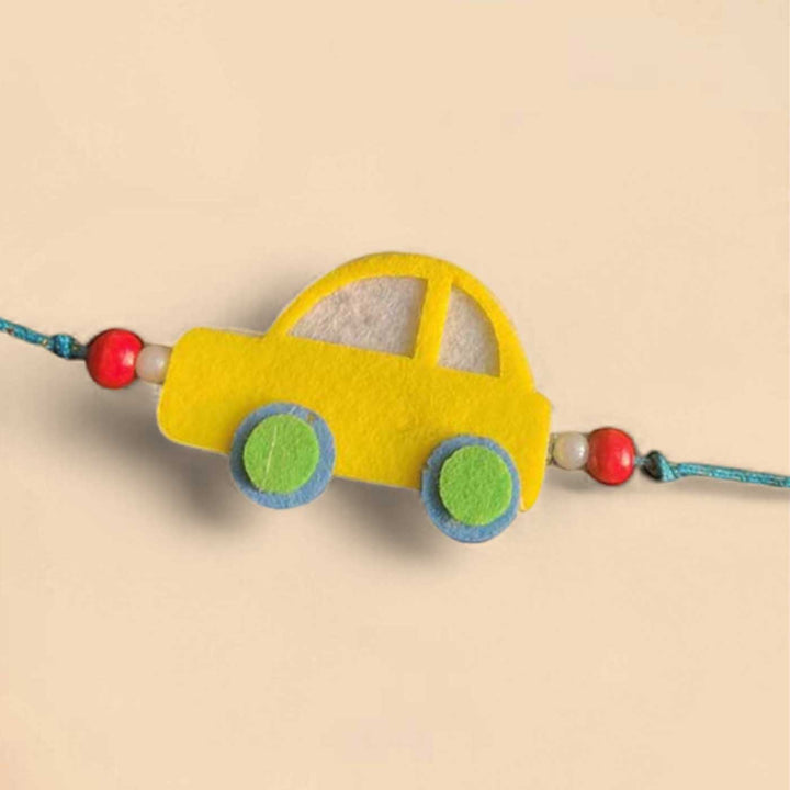 Customized Handmade Beaded Car Theme Pom Pom Felt Rakhi With Roli Chawal For Kids - Yellow Car Bracelet Close-up