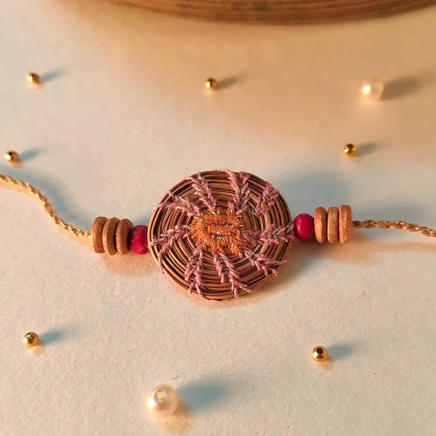 Eco Friendly Handmade Pink And Orange Pine Needle Rakhi With Pouch And Roli Chawal - Close-up of bracelet detail