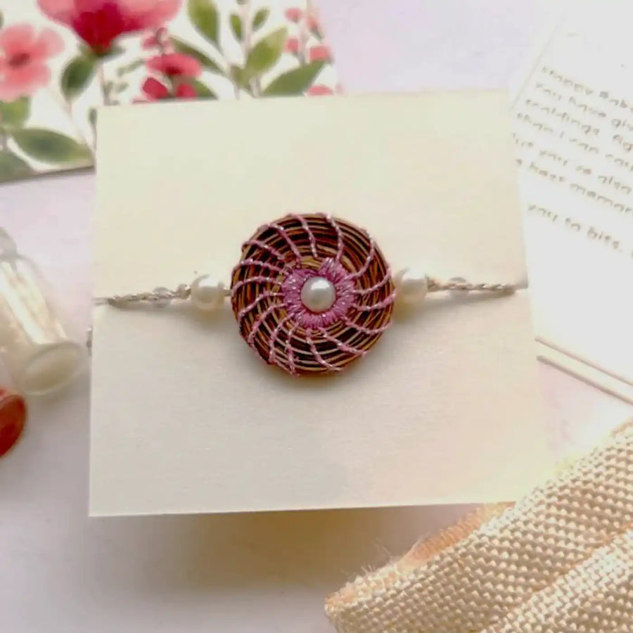 Eco Friendly Handmade Round Pearl Pine Needle Rakhi With Pouch And Roli Chawal - Close-up Front View