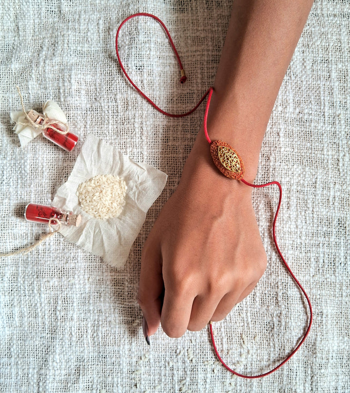 Handmade Papier Mache Naquashi Red Rakhi With Roli Chawal - On Wrist Styling View