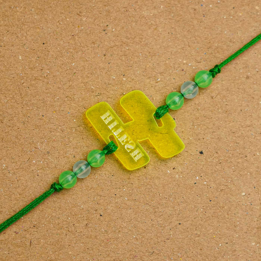 Personalized Handmade Alphabet Name Acrylic Rakhi With Roli Chawal - Close-up of Green Rakhi