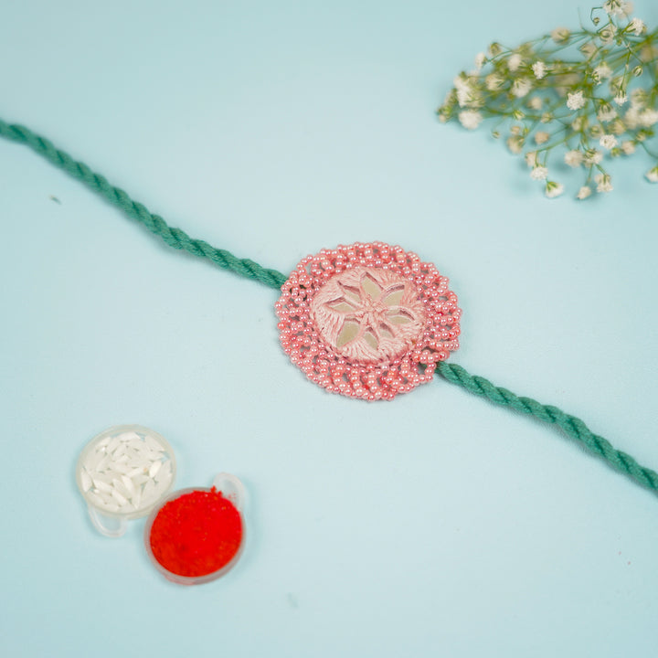 Handmade Reusable Pink And Green Mirror Jhumki Rakhi For Brother - Flat Lay with Decorative Items