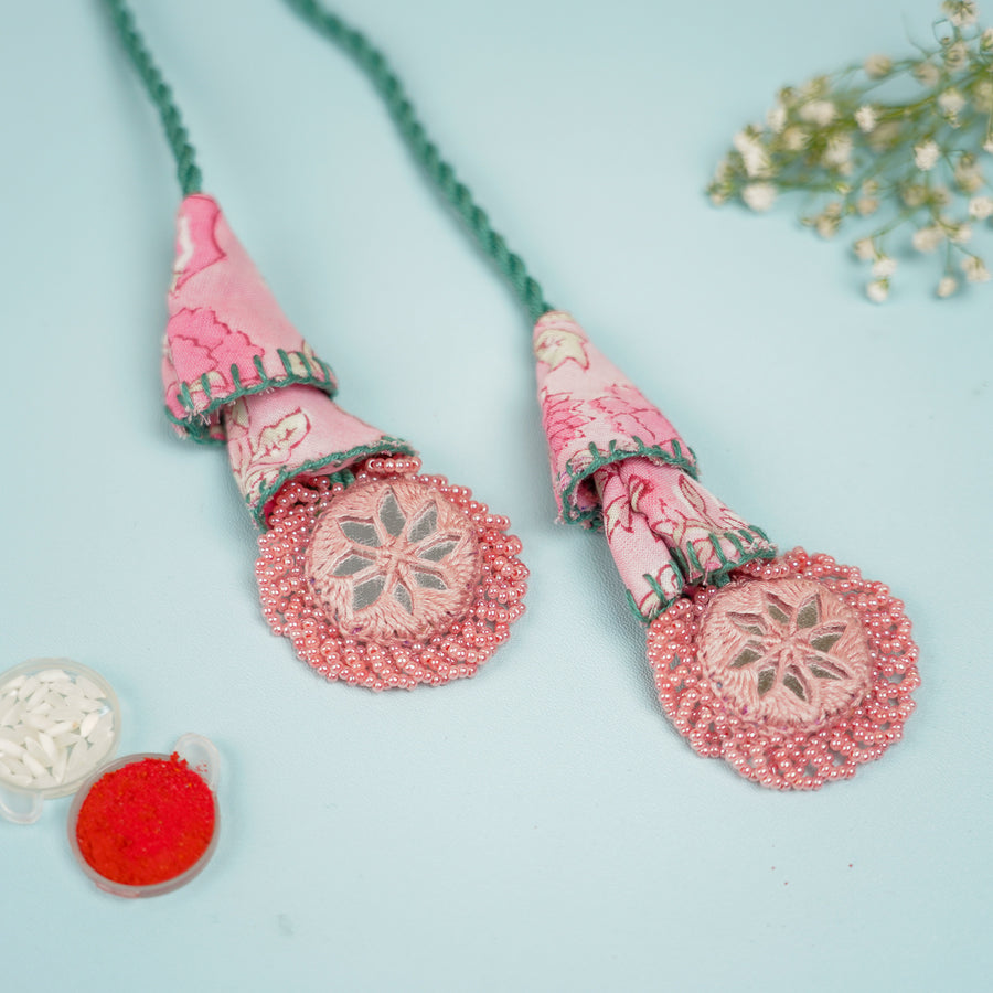Handmade Reusable Pink And Green Mirror Jhumki Rakhi For Bhabhi - Close-up on Embellished Ends
