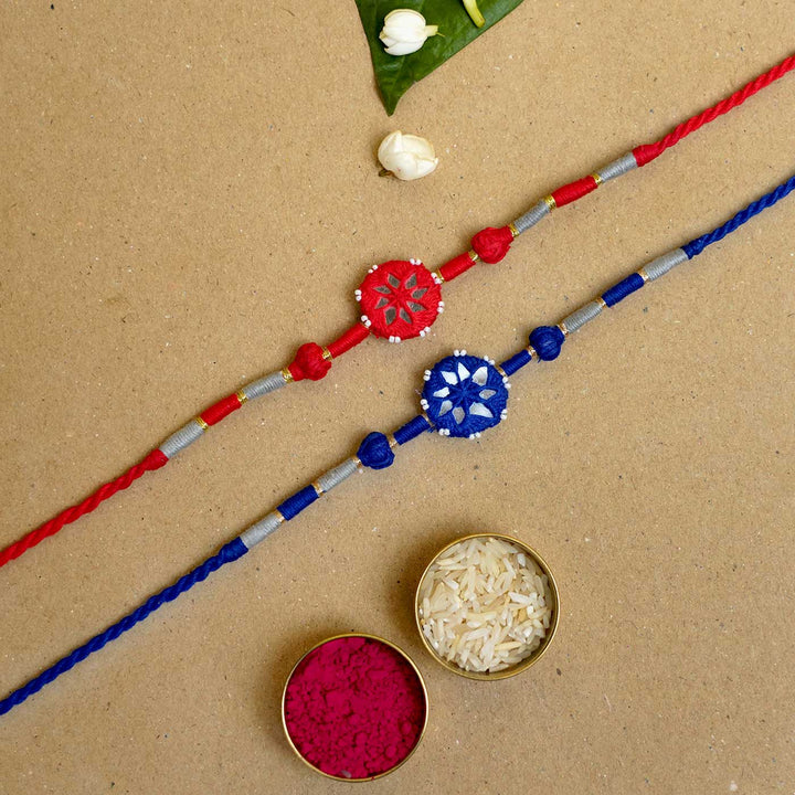 Handmade Mirror Work Patwa Blue Red Cotton Rakhi With Roli Chawal Set Of 2 - Top view with traditional items