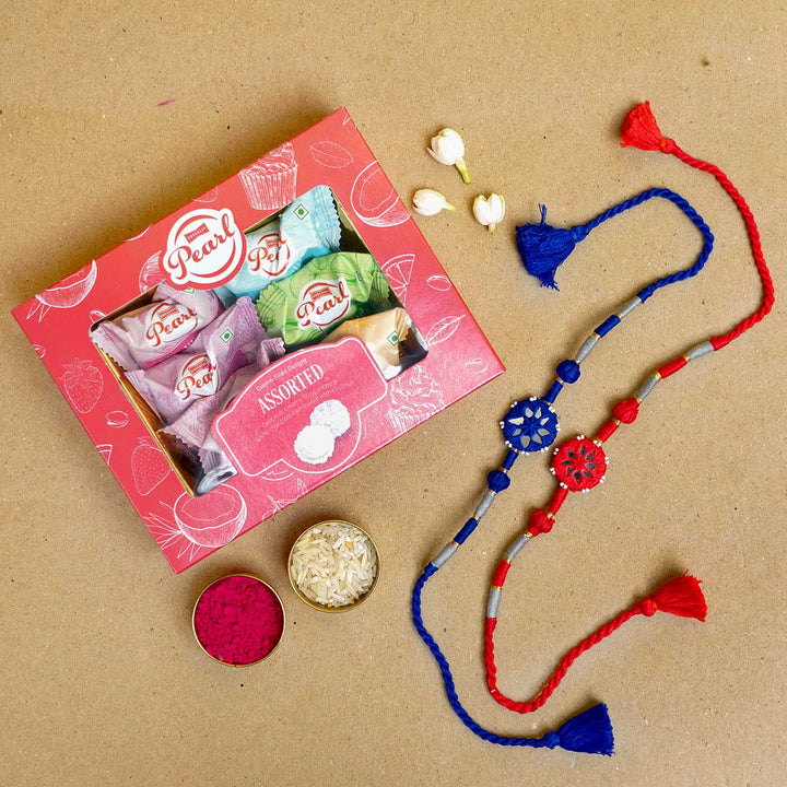 Handmade Mirror Work Patwa Blue Red Cotton Rakhi With Roli Chawal Set Of 2 - Flat lay with sweets and pooja items