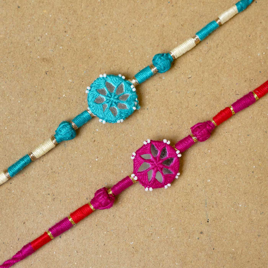 Handmade Mirror Work Patwa Turquoise Blue Pink Cotton Rakhi With Roli Chawal Set Of 2 - Close-up of two Rakhis