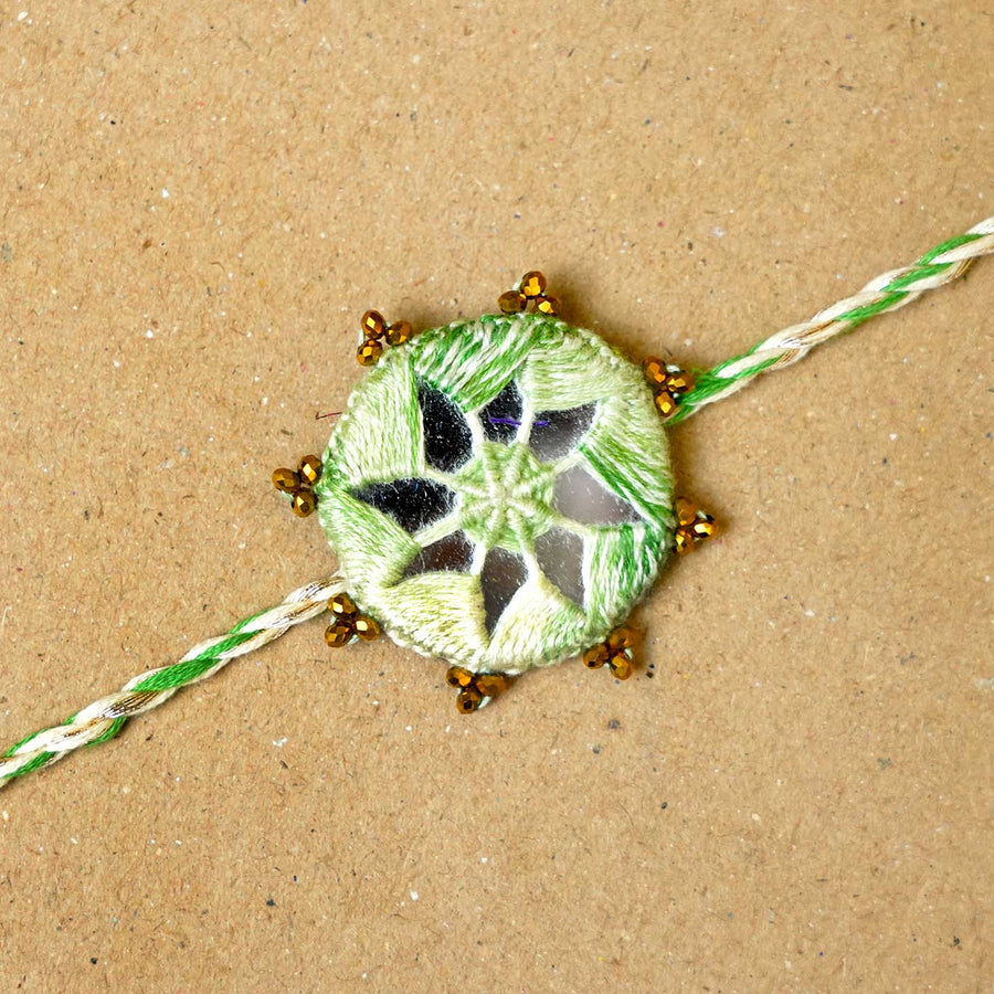 Handmade Mirror Work Kaanha Ombre Green Cotton Rakhi With Roli Chawal - Close-up of central embroidery