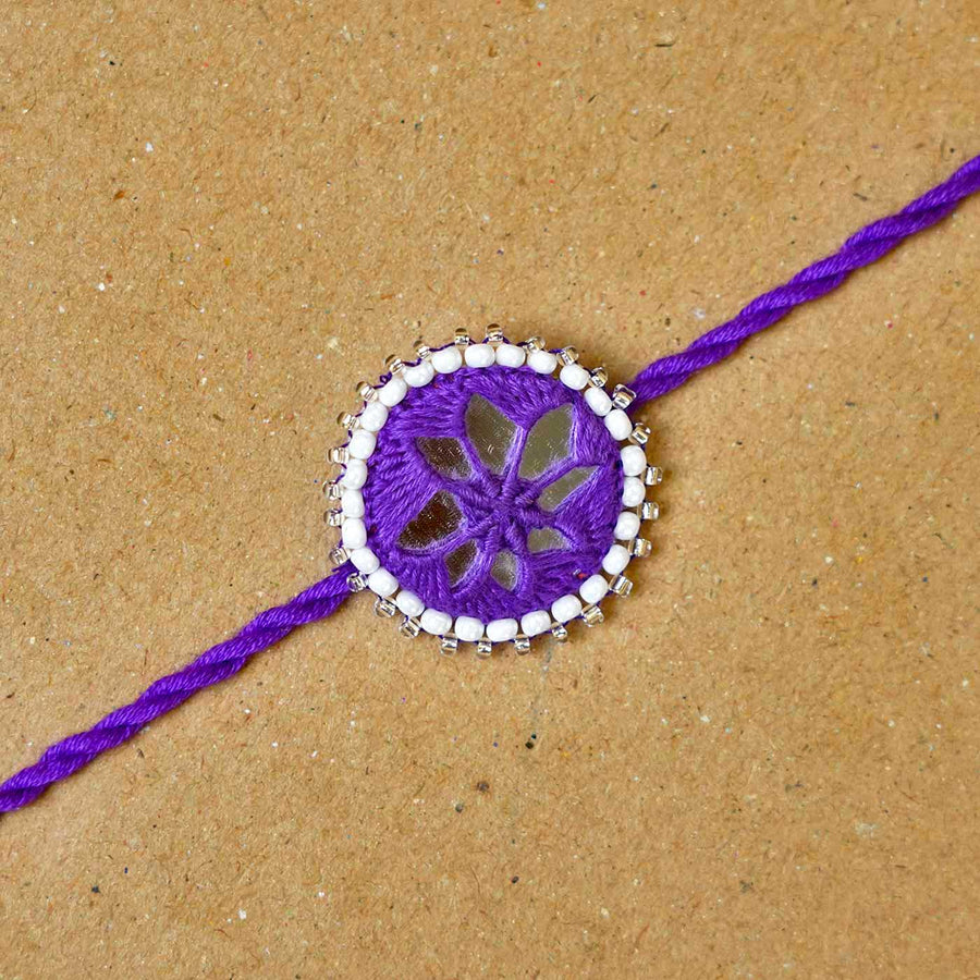 Handmade Mirror Work Kajal Purple Rakhi With Roli Chawal - Close-up of single rakhi