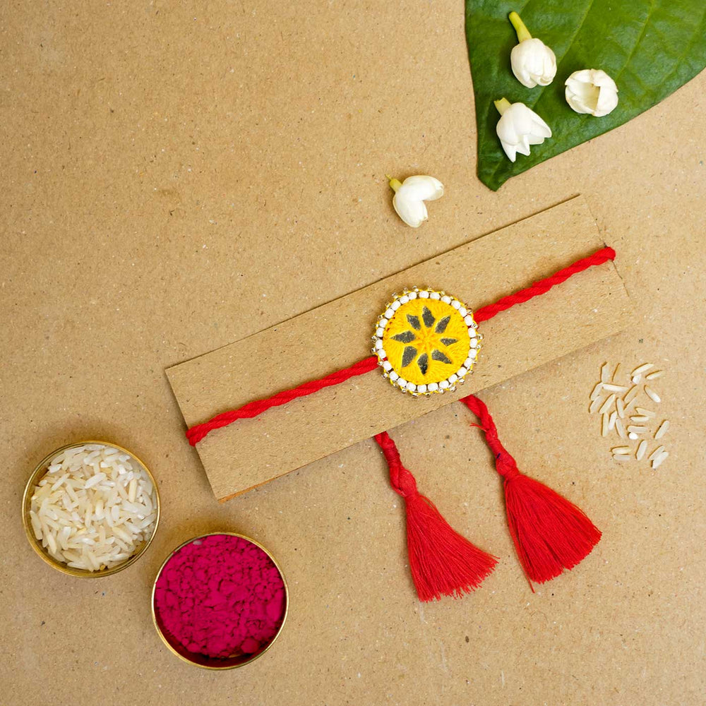 Handmade Mirror Work Kajal Yellow Red Rakhi With Roli Chawal - Rakhi on cardboard with accessories