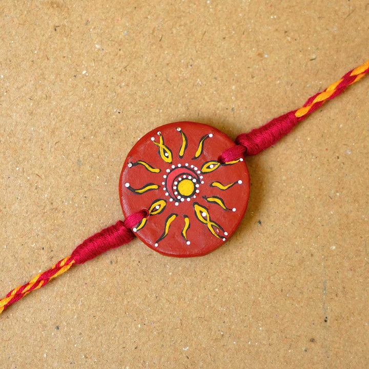 Hand Painted Suraj Chanda Terracotta Rakhi With Roli Chawal - Close-up of Rakhi centerpiece