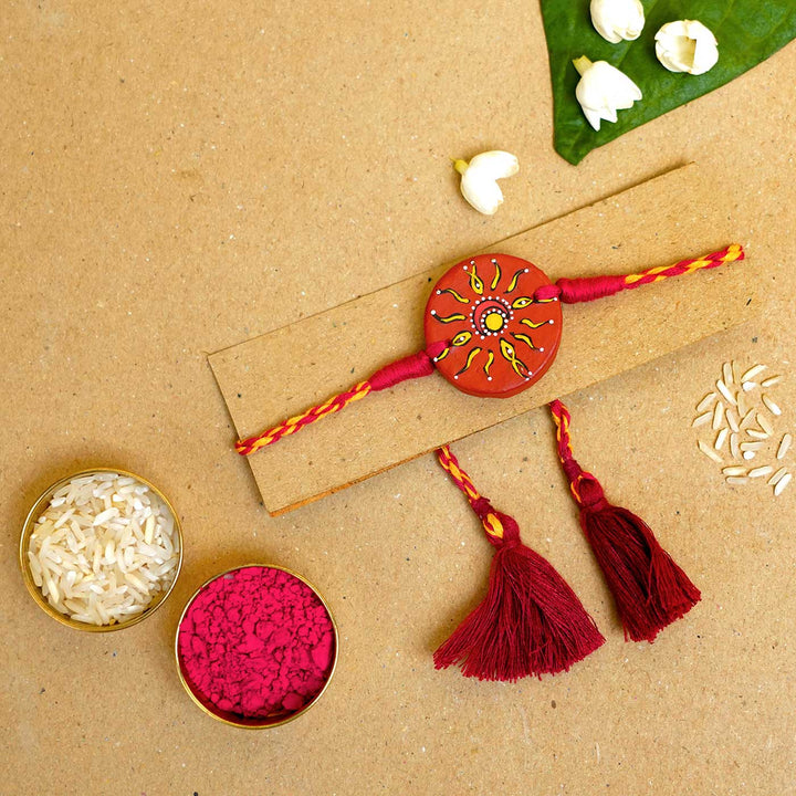 Hand Painted Suraj Chanda Terracotta Rakhi With Roli Chawal - Rakhi on packaging with accessories