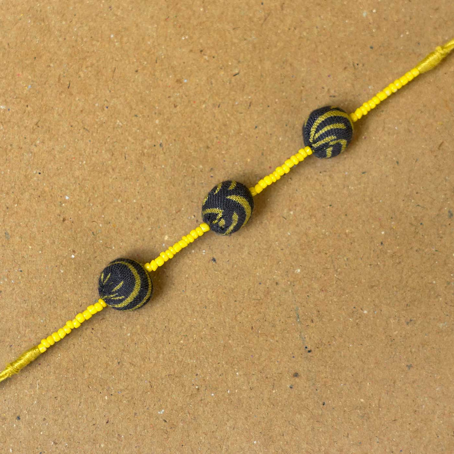 Handmade Swarnamukhi Potli Upcycled Fabric Rakhi With Roli Chawal - Close-up of bracelet beads