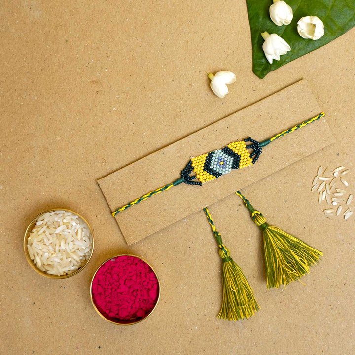 Handmade Beaded Traditional Grace Rakhi With Roli Chawal - Flat Lay with Rakhi and Tikka Items