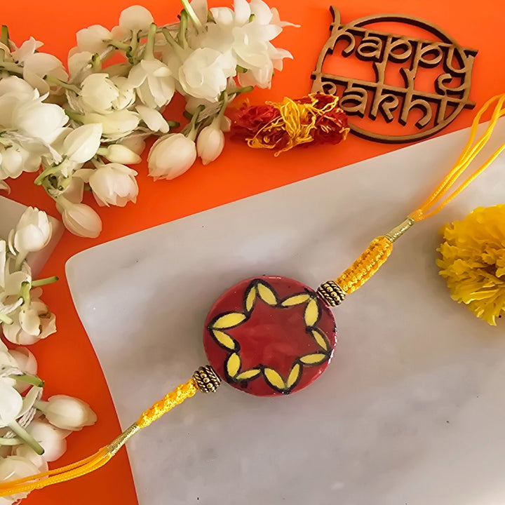 Handmade Red Florwer Design Ceramic Rakhi With Roli Chawal For Brother - Close-up of single rakhi