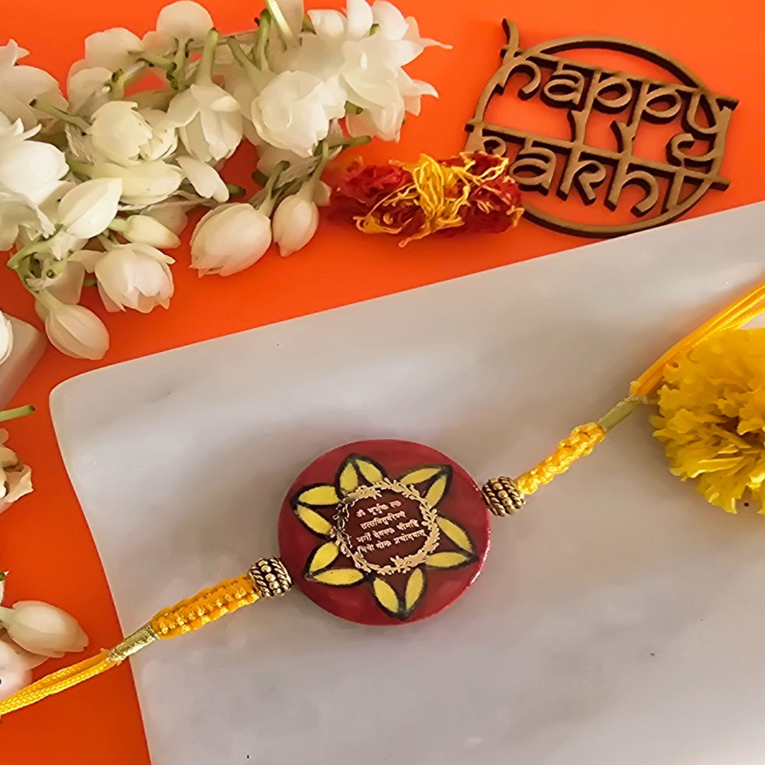 Handmade Red Gayatri Mantra Ceramic Rakhi With Roli Chawal For Brother - Close-up of Rakhi bead and thread