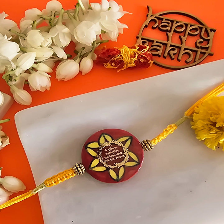 Handmade Red Gayatri Mantra Ceramic Rakhi With Roli Chawal For Brother - Close-up of Rakhi bead and thread