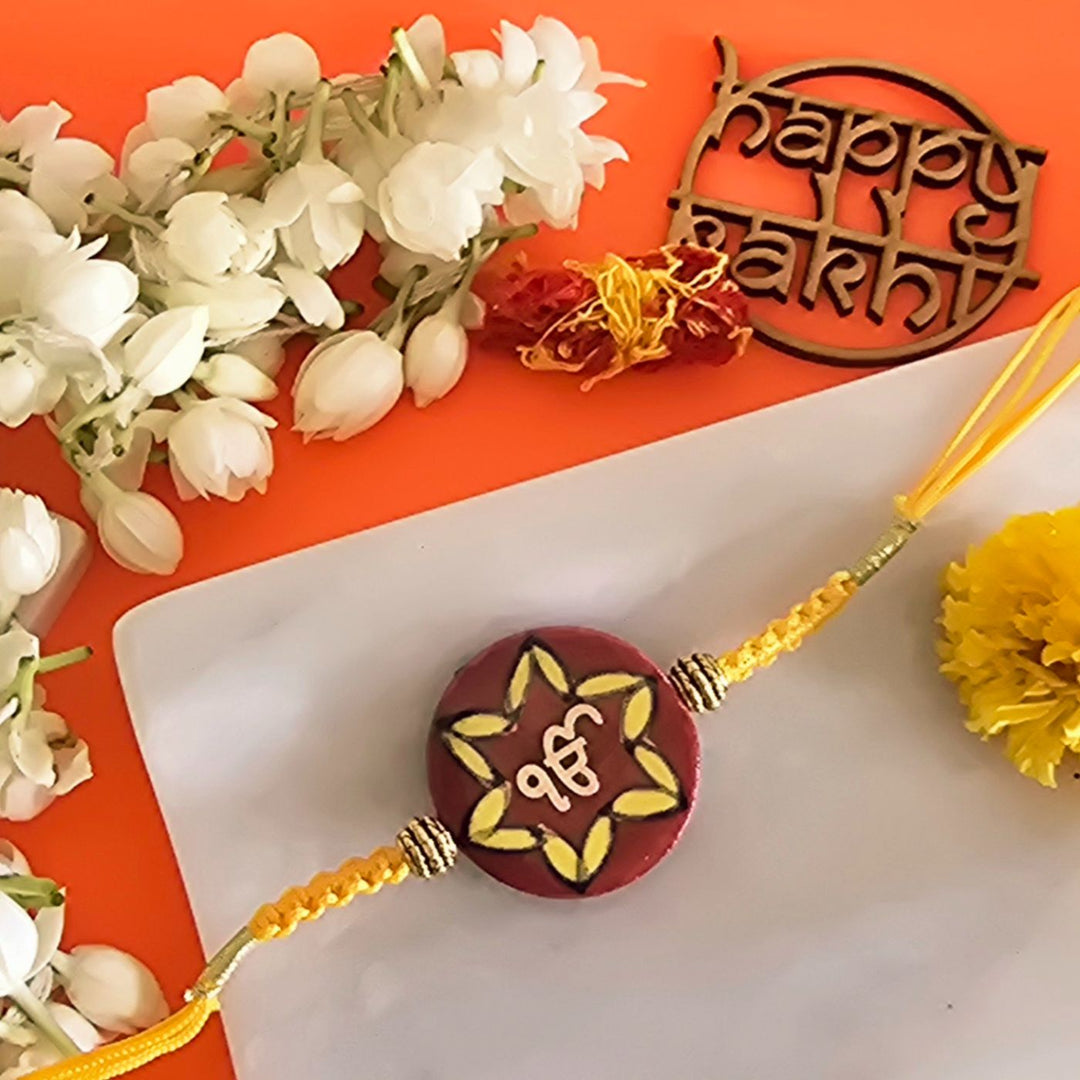 Handmade Laser Cut Red Ik Onkar Ceramic Rakhi With Roli Chawal For Brother - Front View Close-up