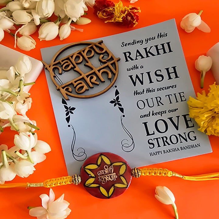 Handmade Laser Cut Red Jai Shree Krishna Ceramic Rakhi With Roli Chawal For Brother - Rakhi with greeting card flat lay
