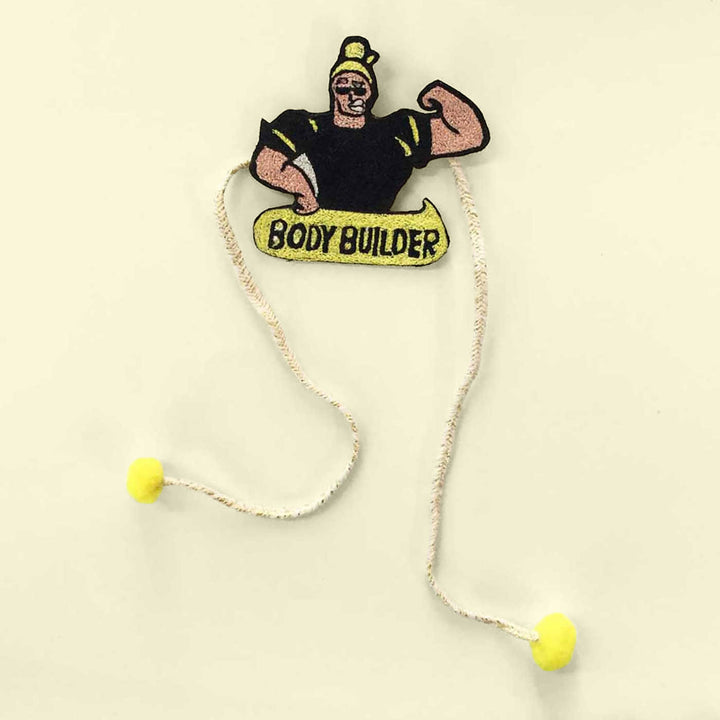 Handmade Reusable Body Builder Pom Pom Felt Kids Rakhi - Top View on Plain Background