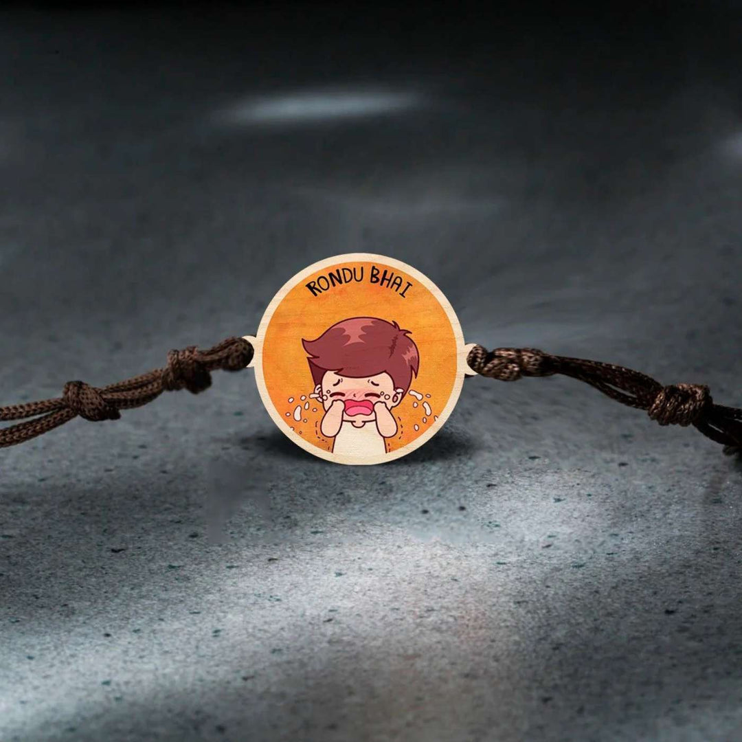 Handmade Rondu Bhai Wooden Rakhi With Roli Chawal - Rakhi on textured surface