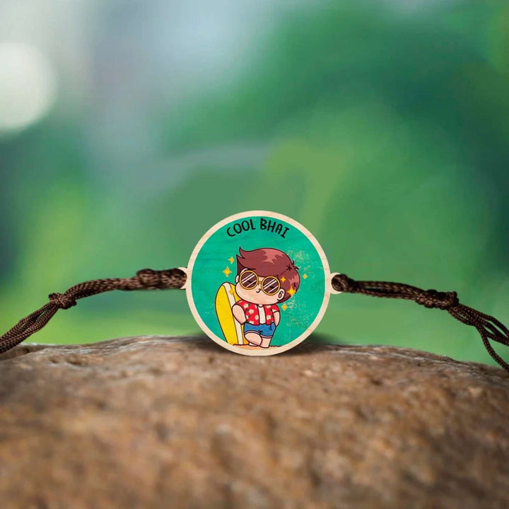 Handmade Cool Bhai Wooden Rakhi With Roli Chawal - Flat Rakhi placed on rock