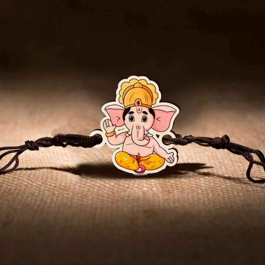 Handmade Ganesha Wooden Rakhi With Roli Chawal - On Fabric Surface Display
