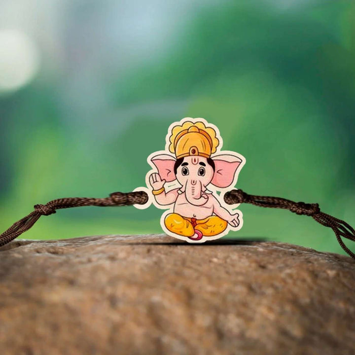 Handmade Ganesha Wooden Rakhi With Roli Chawal - Lying on Rock Display