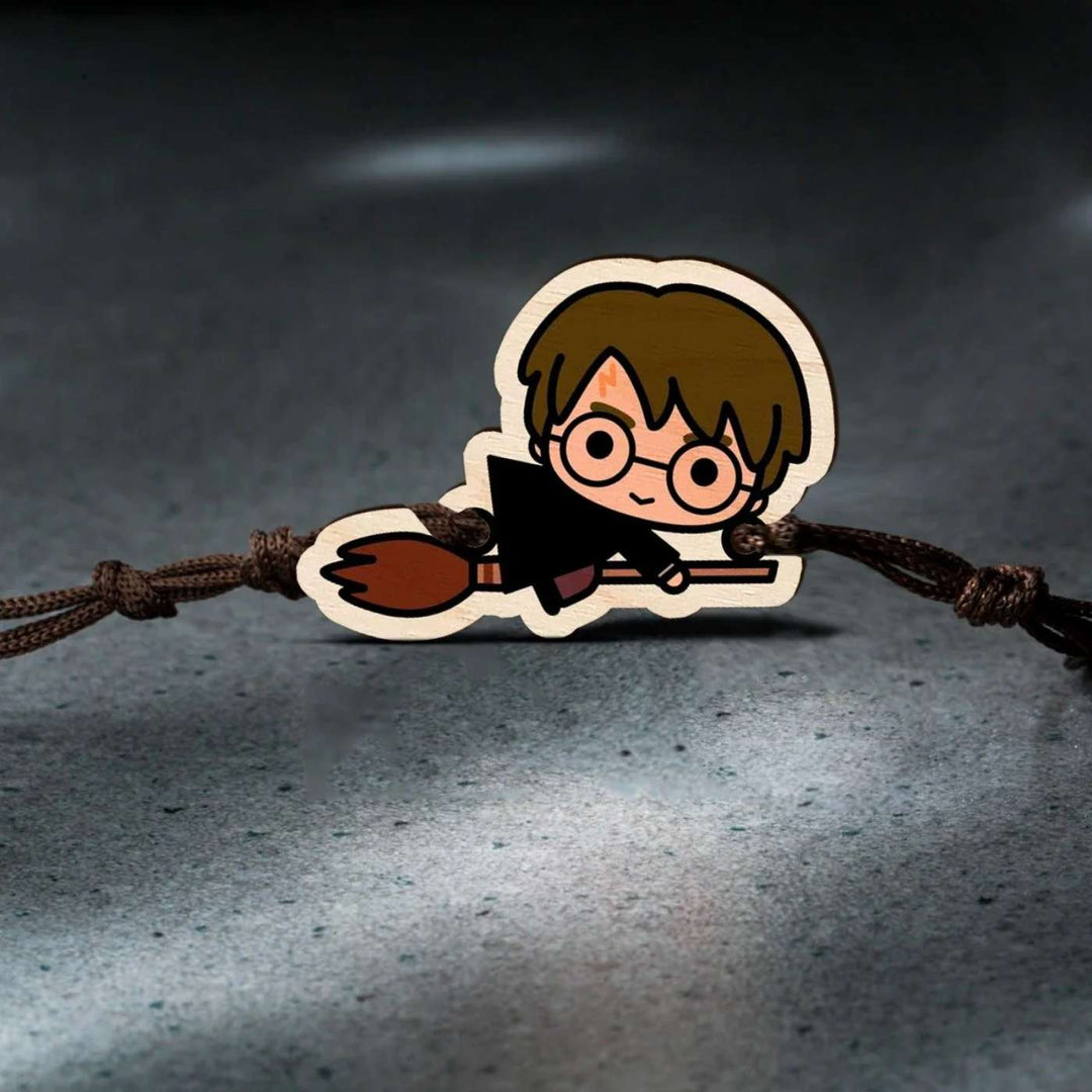 Handmade Harry Potter Broom Wooden Kids Rakhi With Roli Chawal - Rakhi on textured surface