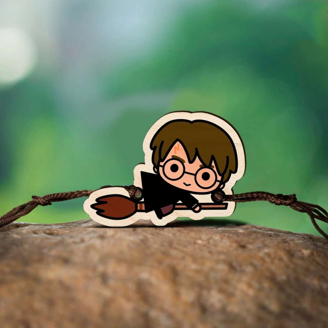 Handmade Harry Potter Broom Wooden Kids Rakhi With Roli Chawal - Rakhi on natural surface