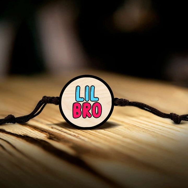 Handmade Little Bro Wooden Rakhi With Roli Chawal - Bracelet laid on wooden surface