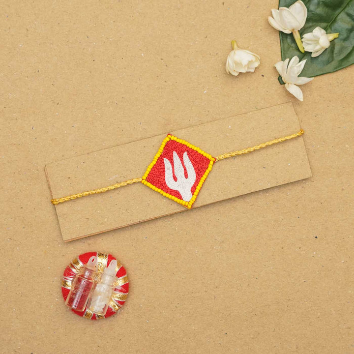 Handmade Beaded Trishul Rakhi With Roli Chawal - Packaged rakhi with decorative items