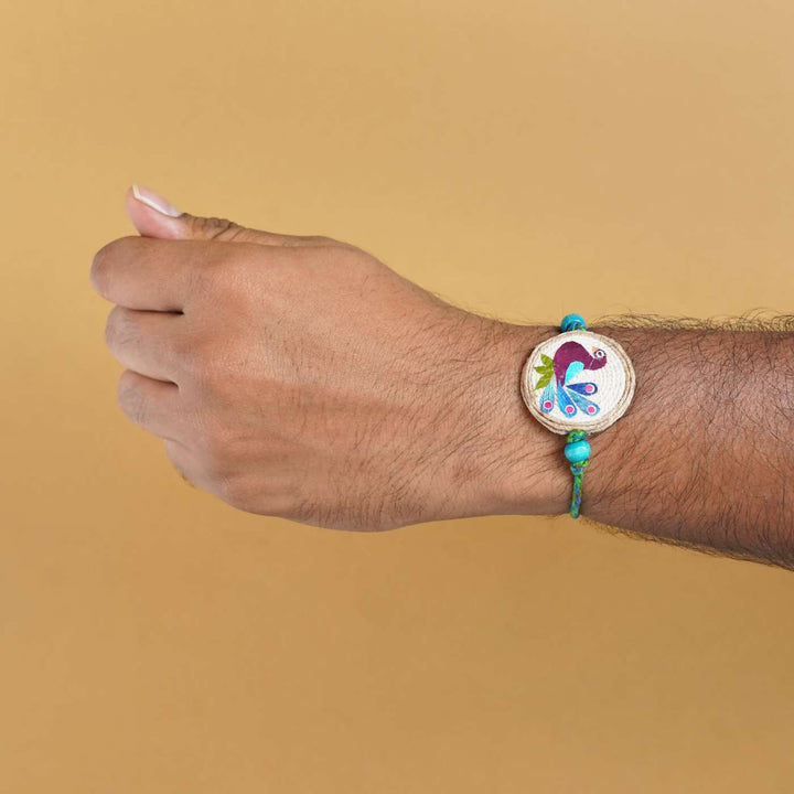 Handmade Pressed Flower Art Peacock Jute Rakhi With Roli Chawal - Bracelet worn on wrist