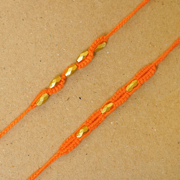 Handmade Macrame Beaded Rakhi With Roli Chawal Set Of 2 - Close-up of orange pair