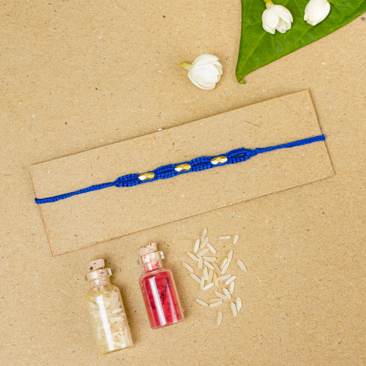 Handmade Macrame Three Gold Beaded Rakhi With Roli Chawal - Displayed on Card with Props