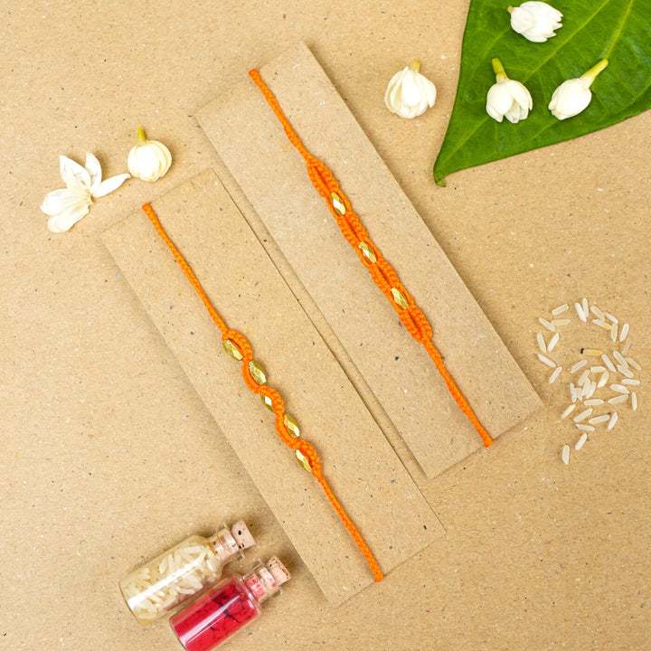 Handmade Macrame Beaded Rakhi With Roli Chawal Set Of 2 - Orange pair on card with decor
