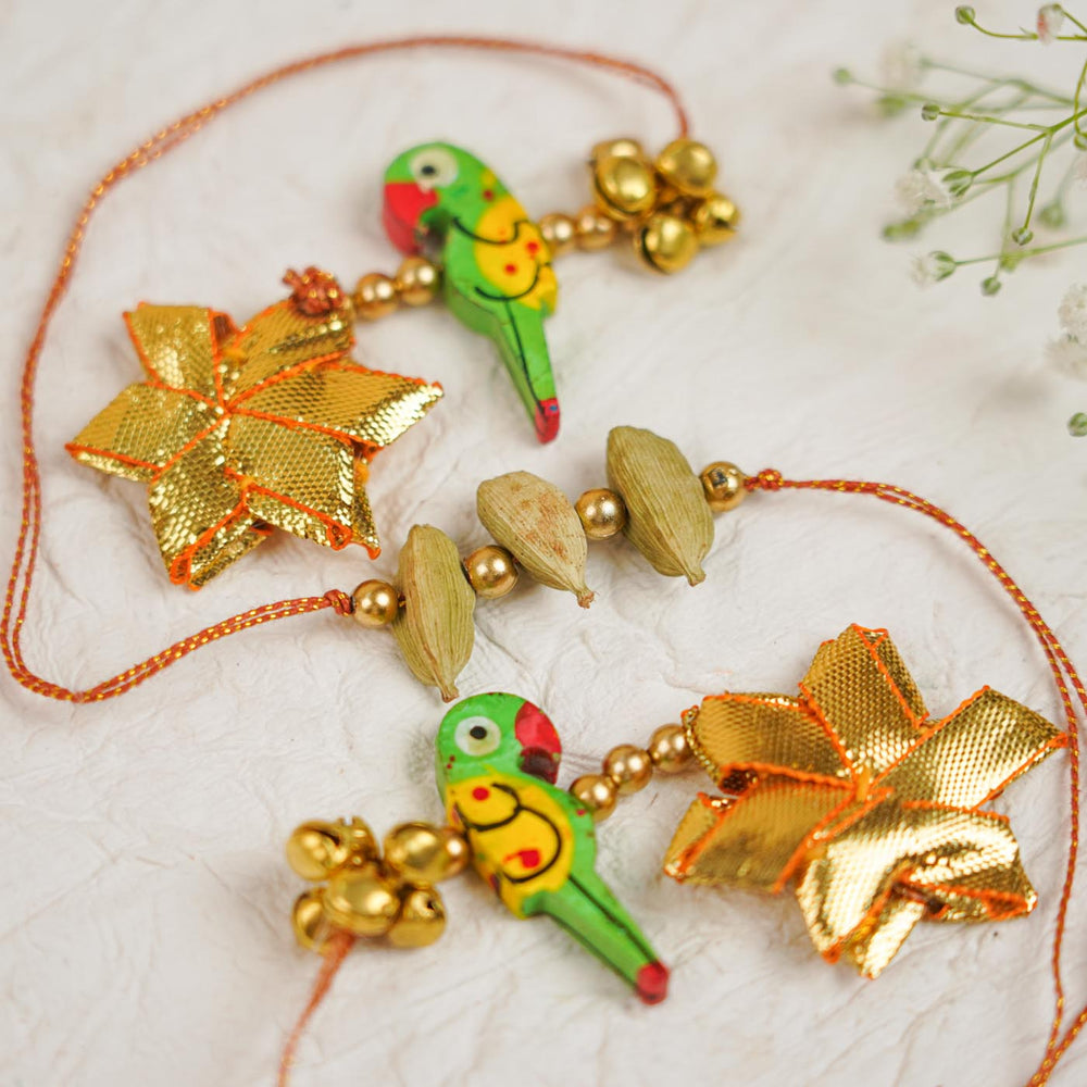 Handmade Sugandh Sutra Parrot Charm And Ghungroo Bhaiya Bhabhi Rakhi With Roli Chawal - Close-up of Decorative Charms
