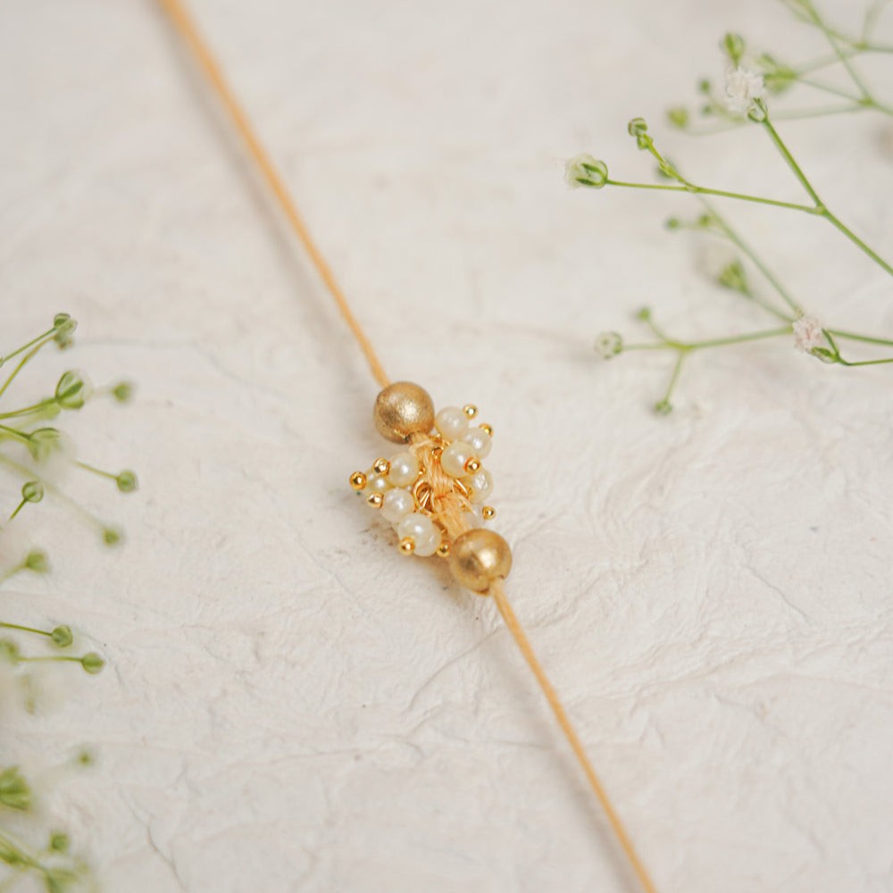 Handmade Single Bajra Ghungroo And Pearl Rakhi With Roli Chawal - Close-up of Central Ornament