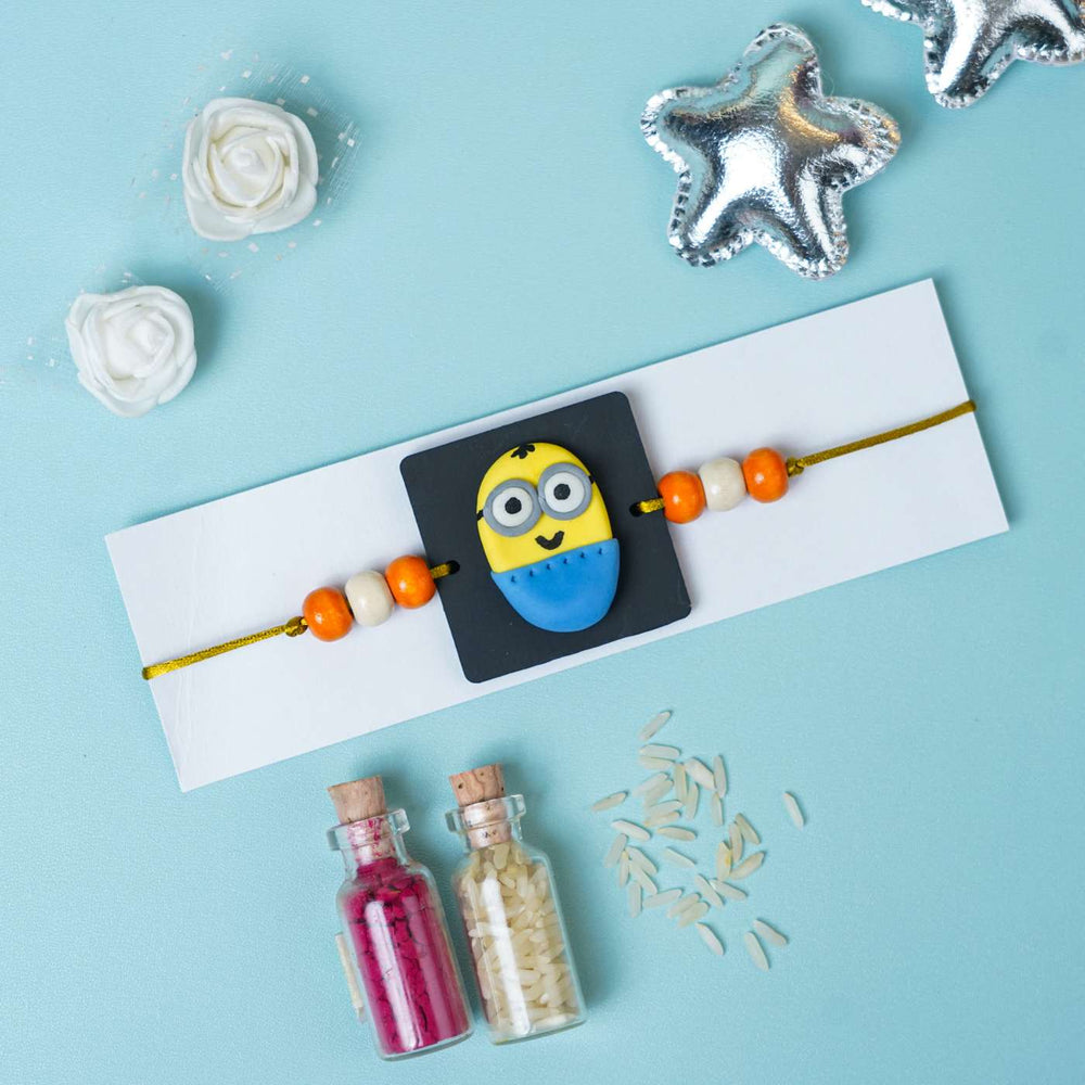 Handmade Miniature Clay Minion Kids Rakhi With Roli Chawal - Flat Lay with Decorative Items